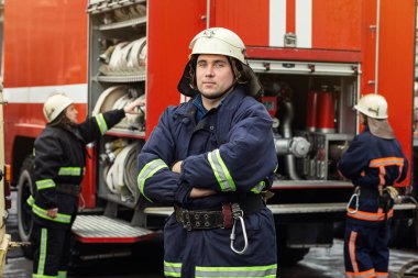 İtfaiyeci (itfaiye) eylem daimi bir firetruck yakınındaki. Emer