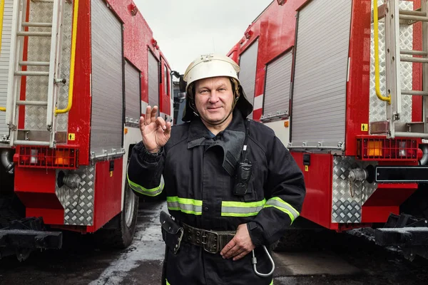 Bombeiro (bombeiro) em ação perto de um caminhão de bombeiros. Emer... — Fotografia de Stock