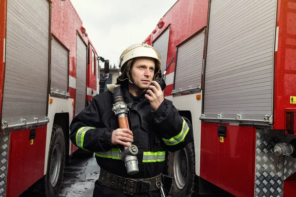 Fireman (firefighter) in action standing  near a firetruck. Emer — Stock Photo, Image