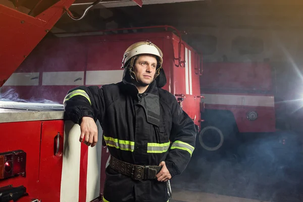 Bombeiro (bombeiro) em ação perto de um caminhão de bombeiros. Segurança de emergência. Protecção, salvamento do perigo . — Fotografia de Stock