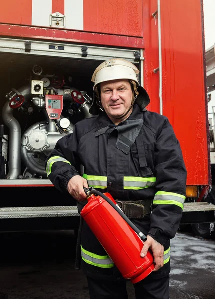 Bombeiro (bombeiro) em ação perto de um caminhão de bombeiros. Emer... — Fotografia de Stock