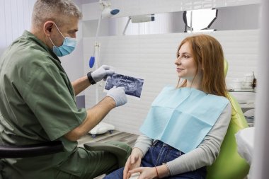 Dişçi klinikte onun hasta için bir x-ışını diş resim ayrıntılarını açıklayan