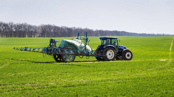 11 of April,2018 - Vinnitsa, Ukraine. Tractor spraying insecticide to the green field, agricultural natural seasonal spring background