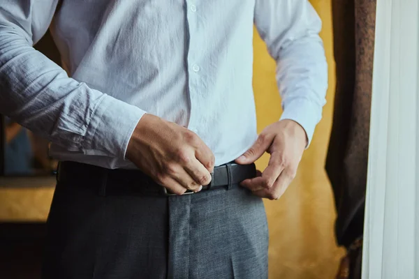 Empresário que põe um cinto, moda e conceito de roupa, noivo que se prepara de manhã antes da cerimônia — Fotografia de Stock