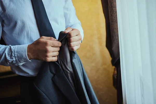 Empresario lleva una chaqueta, manos masculinas primer plano, novio preparándose en la mañana antes de la ceremonia de boda — Foto de Stock