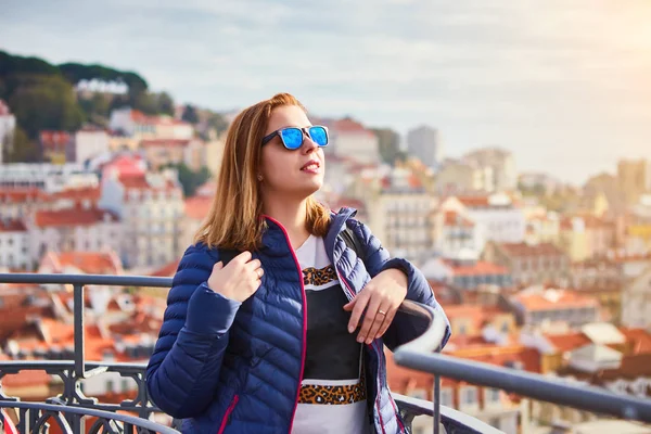 Молодая женщина турист наслаждается красивым видом на город сверху на старый город в солнечный день в Лиссабоне, Португалия — стоковое фото
