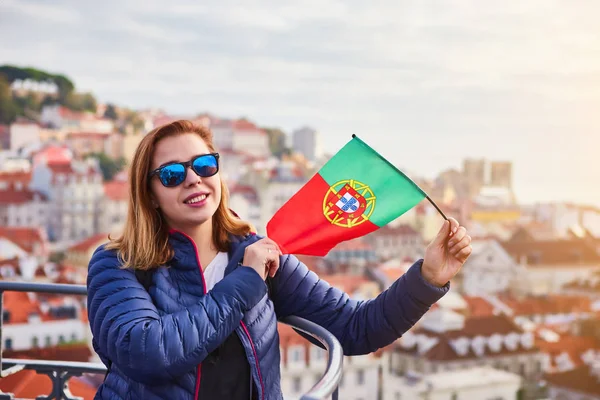 Lizbon şehrinde güneşli bir gün boyunca elinde Portekiz bayrağı tutan eski şehir manzarası güzel şehir manzarası zevk genç kadın turist