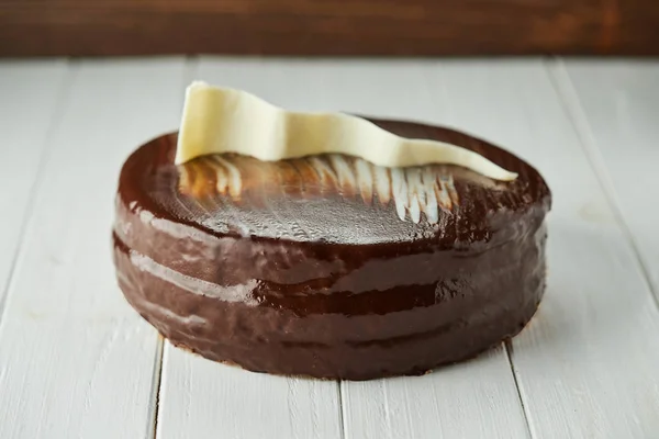 Темный шоколадный веганский торт с конфетами и орехами на деревянном нарте — стоковое фото