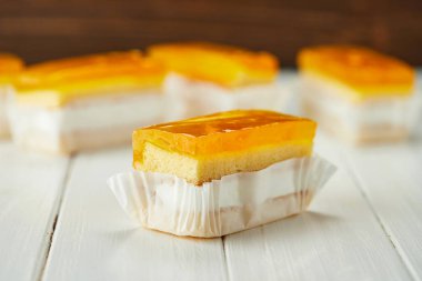 Ahşap arka planda turuncu jöleli kek.