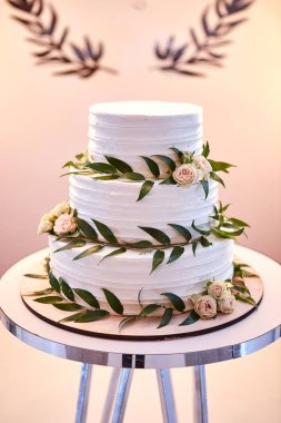 Çok katlı düğün pastası beyaz tonda süslenmiş güzel çiçeklerle