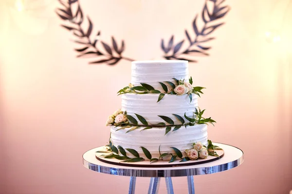 Wesele uroczysty wielopiętrowy tort w białym tonie ozdobione pięknymi kwiatami — Zdjęcie stockowe