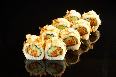 Geleneksel suşi rulosu, somon, krem peynir ve siyah taşta salatalık. Japon yemeği.