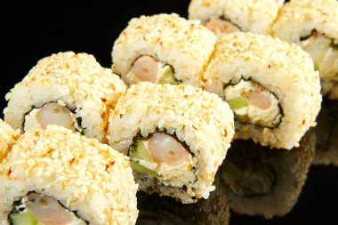 Geleneksel suşi rulosu, karides, krem peynir ve siyah taşta salatalık. Japon yemeği.