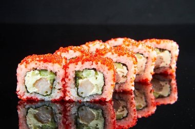 Geleneksel suşi rulosu, karides, krem peynir, havyar ve siyah taşta salatalık. Japon yemeği.