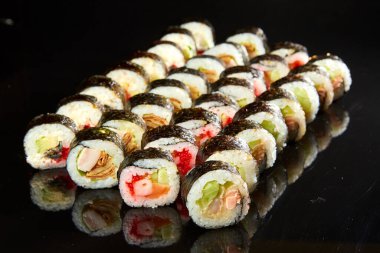 Siyah taşla servis edilen çeşitli suşi çeşitleri. Japon yemeği.