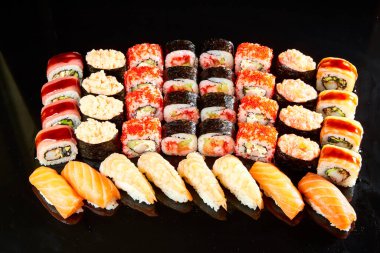 Siyah taşla servis edilen çeşitli suşi çeşitleri. Japon yemeği.