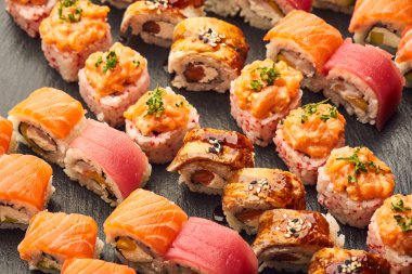 Siyah taşla servis edilen çeşitli suşi çeşitleri. Japon yemeği.
