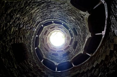 Quinta da Regaleira 'nın başlangıç kuyusu yer altına inen ve yer altından diğer tünellere bağlanan 27 metrelik bir merdiven. Sintra, Portekiz 'de bulunmaktadır..