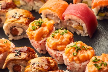 Siyah taşla servis edilen çeşitli suşi çeşitleri. Japon yemeği.