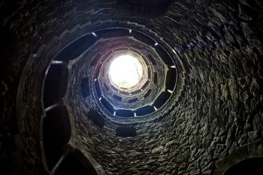 Quinta da Regaleira 'nın başlangıç kuyusu yer altına inen ve yer altından diğer tünellere bağlanan 27 metrelik bir merdiven. Sintra, Portekiz 'de bulunmaktadır..