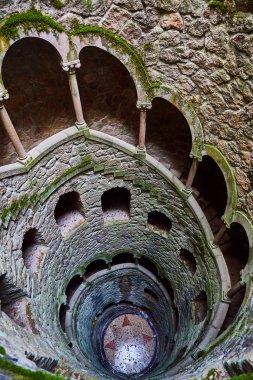 Quinta da Regaleira 'nın başlangıç kuyusu yer altına inen ve yer altından diğer tünellere bağlanan 27 metrelik bir merdiven. Sintra, Portekiz 'de bulunmaktadır..