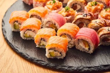 Siyah taşla servis edilen çeşitli suşi çeşitleri. Japon yemeği.