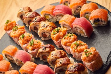 Siyah taşla servis edilen çeşitli suşi çeşitleri. Japon yemeği.