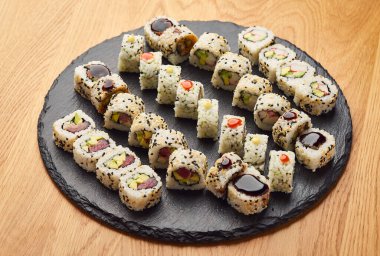 Siyah taşla servis edilen çeşitli suşi çeşitleri. Japon yemeği.