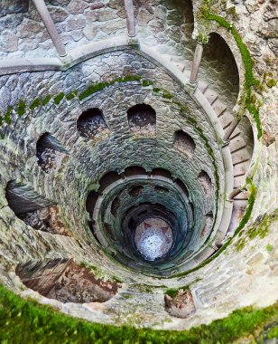 Quinta da Regaleira 'nın başlangıç kuyusu yer altına inen ve yer altından diğer tünellere bağlanan 27 metrelik bir merdiven. Sintra, Portekiz 'de bulunmaktadır..