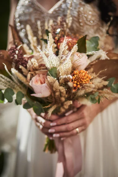 bouquet in hands of the bride, woman getting ready before wedding ceremony