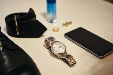 Bir iş adamının farklı aksesuarları ahşap bir arka planda yatar.