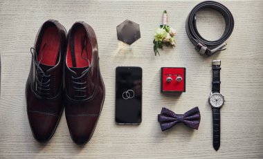 Bir iş adamının farklı aksesuarları ahşap bir arka planda yatar.