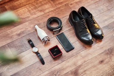 Bir iş adamının farklı aksesuarları ahşap bir arka planda yatar.