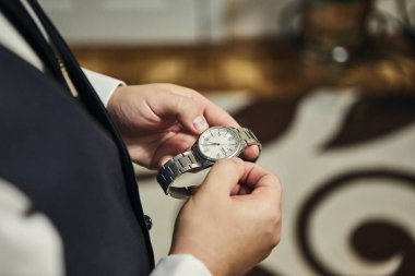 İş adamı kol saatini kontrol ediyor, saati eline alıyor, damat düğün töreninden önce hazırlanıyor. Erkekler Moda