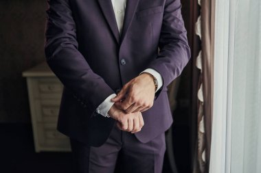 İş adamı ceket giyiyor, erkek eli kapalı, damat düğün töreninden önce hazırlanıyor.