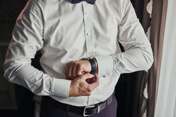 実業家が腕時計の時刻を調べてる男が時計を手にして結婚式の前の朝に新郎が準備をしてる 男性ファッション — ストック写真