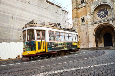 Lizbon, Portekiz, 14 Aralık 2018: Tahta tarihi klasik sokak tramvayı 28 Lizbon Katedrali yakınına ilerliyor. Yerel halk için vazgeçilmez ulaşım ve turistler için ilginç bir cazibe