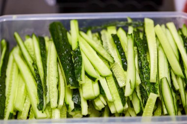 Kesme tahtasında dilimlenmiş salatalık. Sebzeler salata için hazır. Lezzetli diyet vejetaryen yemekleri