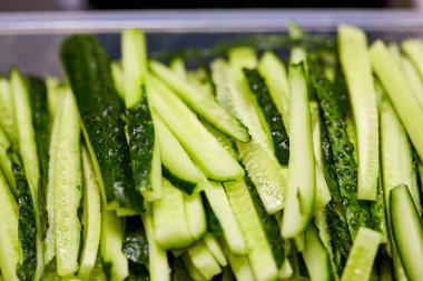 Kesme tahtasında dilimlenmiş salatalık. Sebzeler salata için hazır. Lezzetli diyet vejetaryen yemekleri