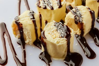 Muz, çikolata ve krem peynirden ya da ricotta 'dan yapılmış lezzetli ev yapımı tatlı. Muz beyaz bir tabakta yuvarlanıyor. Çocuklar için ikramlar