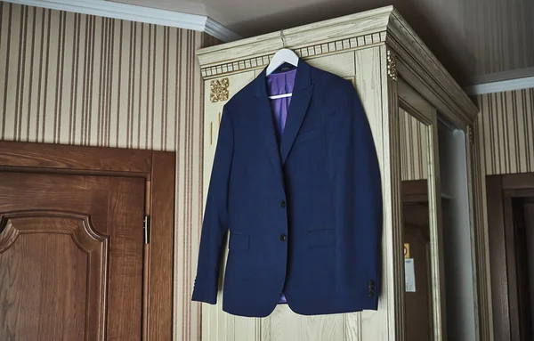 men\'s suit hanging in the room