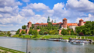 Wawel Kalesi - Krakow Polonya 'nın ünlü simgesi. Güneşli bir günde Vistula nehri kıyısındaki resim manzarası.