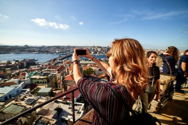 12 Ekim 2019 - İstanbul, Türkiye: Akıllı telefonuyla fotoğraf çeken güzel bir turist kız Galata Kulesi 'nin tepesinden İstanbul' un tarihi merkezinin keyfini çıkarıyor