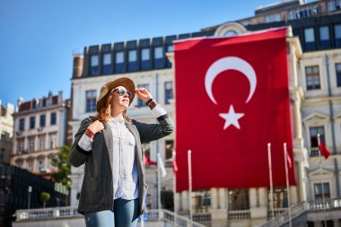 İstanbul 'daki Beyoğlu Belediye Binası' nda Türk bayrağının arka planında duran çekici genç bayan turist