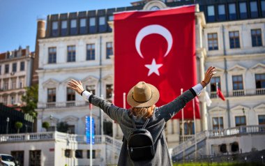 İstanbul 'daki Beyoğlu Belediye Binası' nda Türk bayrağının arka planında duran çekici genç bayan turist
