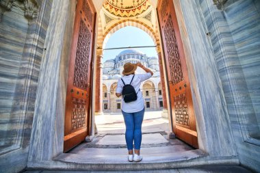 Şapkalı mutlu çekici kadın turist, İstanbul, Türkiye 'deki Süleyman camisinin avlusunun önünde poz veriyor. Din ve seyahat kavramı.