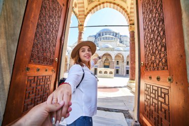Beni takip edin. Şapkalı bir kadın turist, arkadaşını İstanbul, İstanbul 'daki Türk camisine götürüyor. Seyahat ve din kavramı.