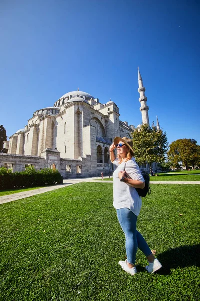 Ευτυχισμένη Ελκυστική Γυναίκα Τουρίστρια Καπέλο Ποζάρει Στο Βάθος Του Τζαμιού — Φωτογραφία Αρχείου