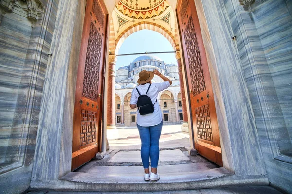 在土耳其伊斯坦布尔苏莱曼涅清真寺庭院入口处 一位戴着帽子的漂亮女性游客摆姿势 她很快乐 宗教和旅行概念 — 图库照片