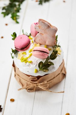 Beyaz ahşap arka planda Paskalya Tavşanı pastası geleneksel Kulich, Paska kutlamaya hazır.
